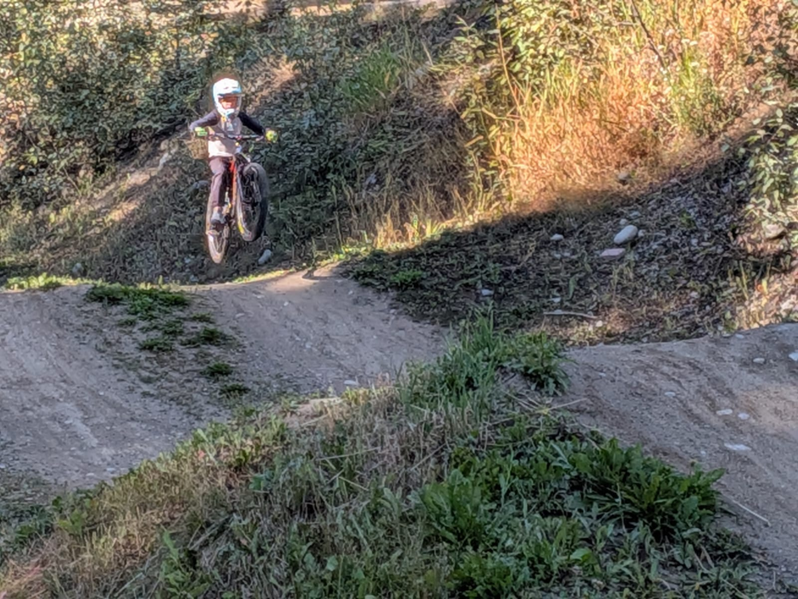 Leo smiling in a full-face helmet while standing with his mountain bike in Whistler.